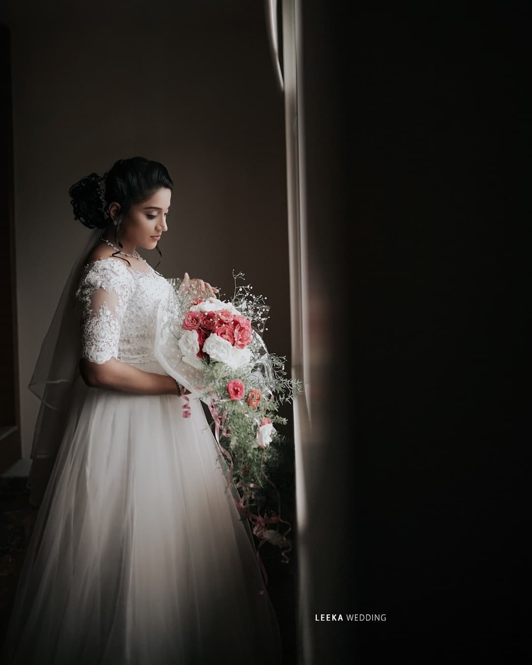 A wedding photographer in Bangalore capturing a moment of a bride lifting flower in her arms