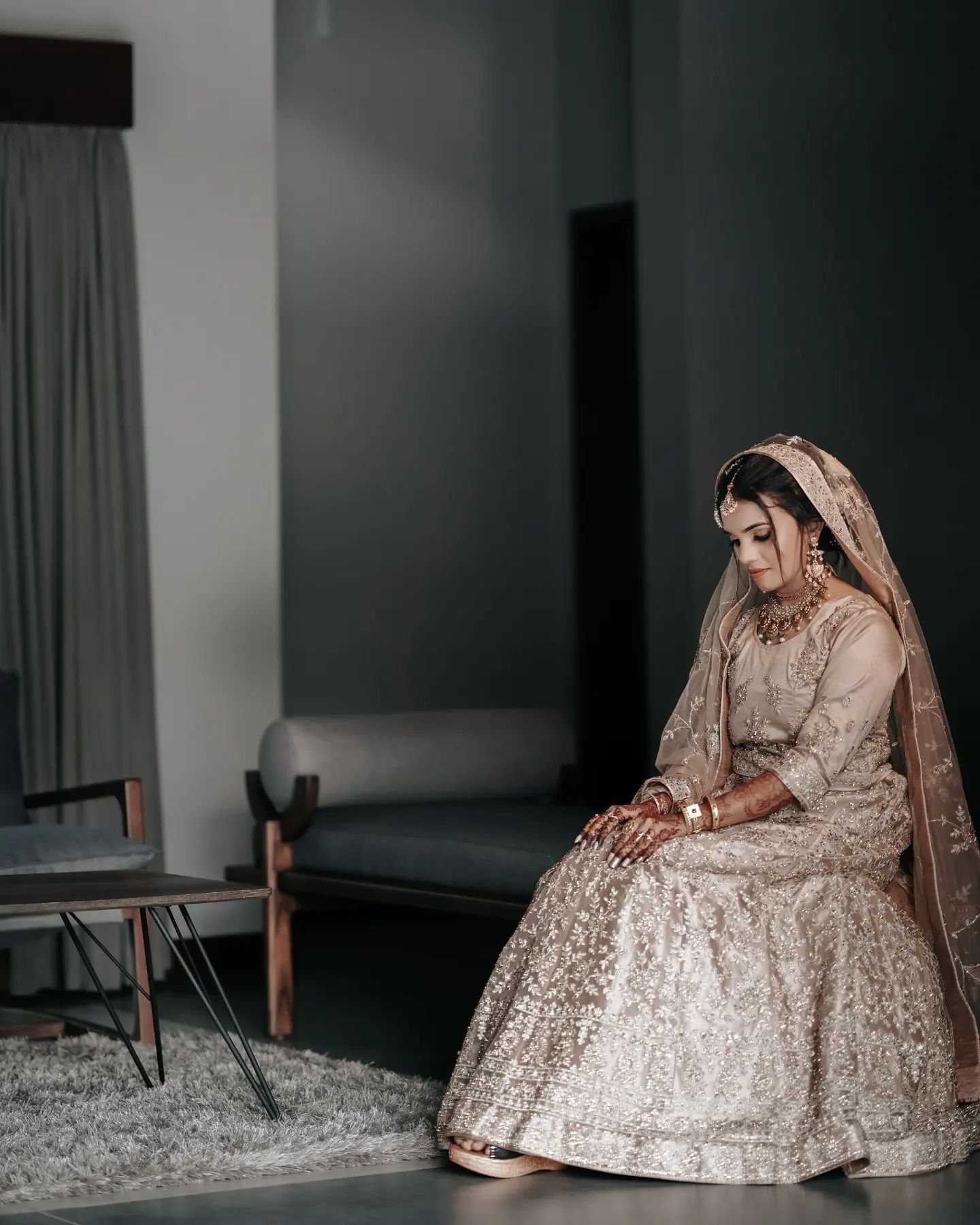 A wedding photographer in Bangalore taking a photo of a bride sitting on a empty room